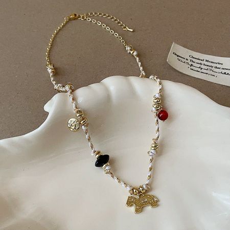 Close-up of the gold-plated brass chain and horse pendant on the bohemian necklace.