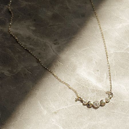 The 18k gold plated necklace showcasing the five circular gemstone design.