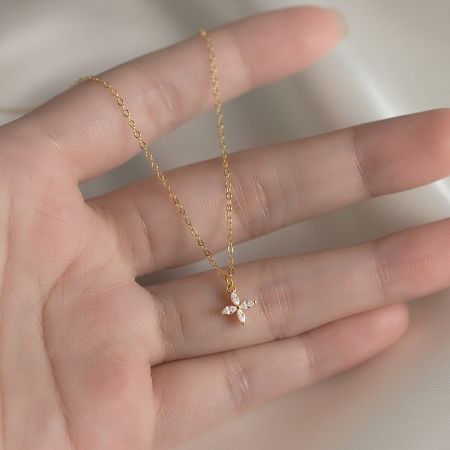 Detailed view of the gold four-leaf clover pendant necklace.