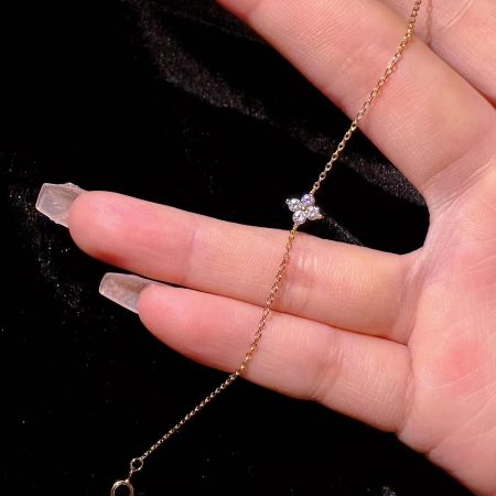 Close-up view of the dainty gold-plated 925 silver anklet with a sparkling CZ four-leaf clover charm.