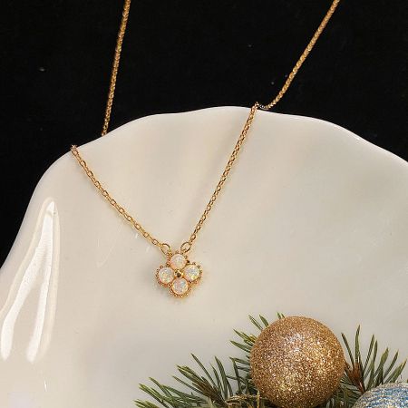 The clover opal necklace displayed elegantly on a ceramic dish with festive decorations.