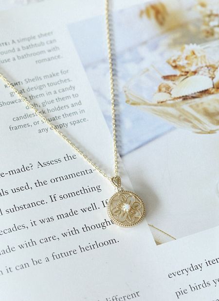 Lifestyle shot of the 925 Sterling Silver Opal Round Necklace displayed elegantly on a book.