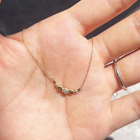 Detailed view of the smile disc necklace pendant with a central clear gemstone.