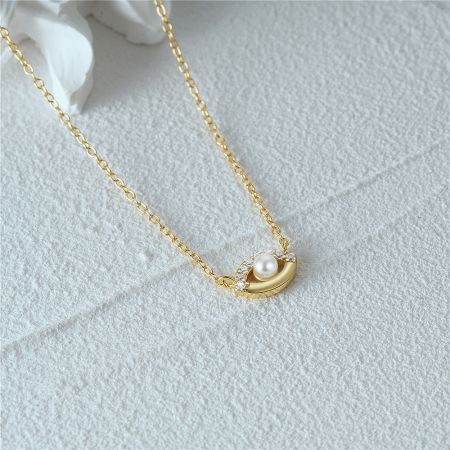 A complementary crescent moon design from the gold necklace set.