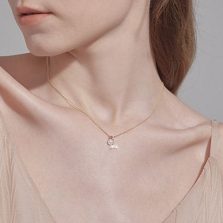 Model wearing the elegant gold necklace with a pearl and wing pendant.