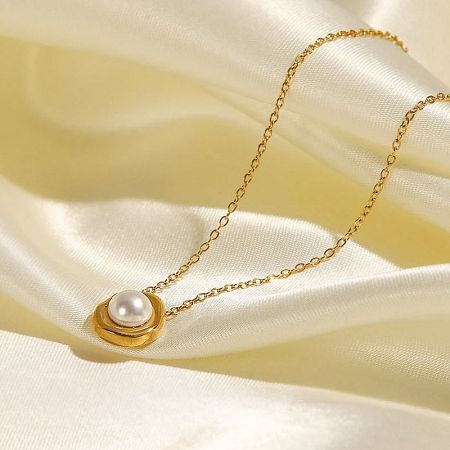 Studio product shot of the stainless steel gold pearl necklace on a neutral background.