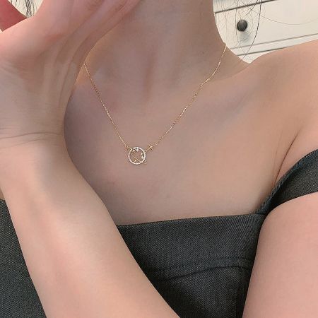 Showcase of the gold necklace with its celestial-themed pendant.