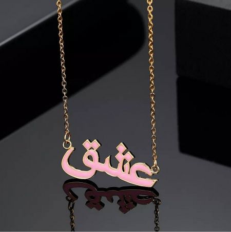 Custom gold necklace with a pink enamel pendant featuring Arabic calligraphy for 'love'.