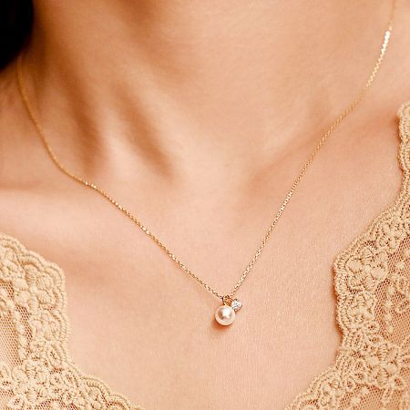 Wholesale 925 Sterling Silver Single Pearl with Zircon Stone Necklace (Set of 5) - A close-up of a wholesale 925 sterling silver necklace with a single pearl and zircon stone pendant, shown in a gold finish.