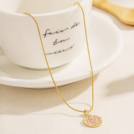 Close-up view of the 18K gold plated flower pendant necklace, highlighting the pink enamel detail.