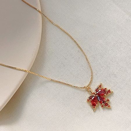 Detailed shot of the maple leaf pendant, highlighting the craftsmanship and sparkling zircon.