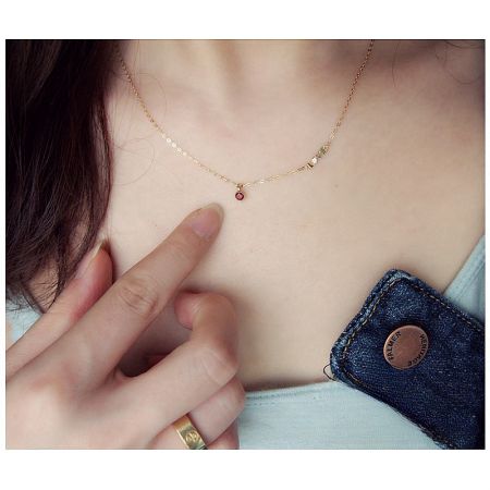 Close-up of the love pendant necklace, highlighting the vibrant red cubic zirconia stone.