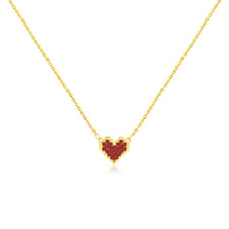 Detail of the gold necklace with a vibrant red heart-shaped pendant.