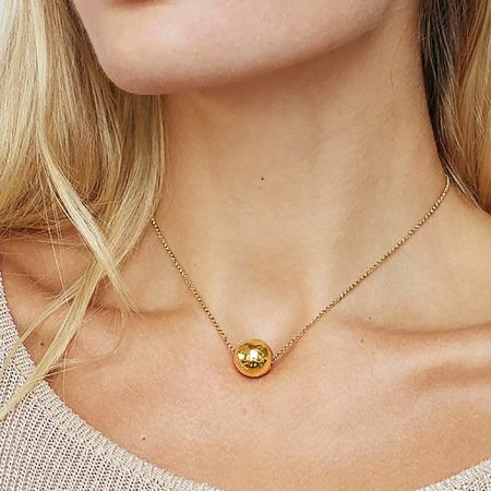 Model wearing the gold single ball pendant necklace, showcasing its length and style.