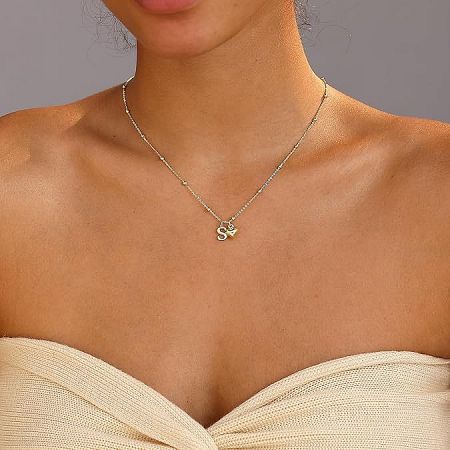 Detailed view of the gold heart necklace with a stylish 'S' initial pendant.