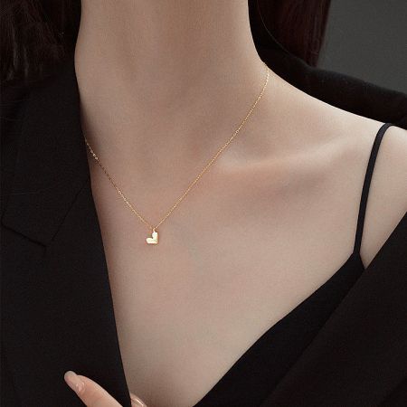 A gold necklace with a small heart pendant, highlighting its delicate design.