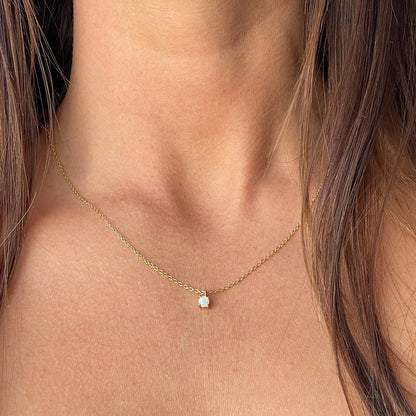 A model wearing the 4mm opal stone necklace in gold, showcasing its elegant simplicity.