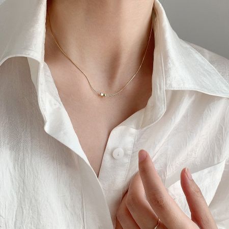 A gold-plated sterling silver necklace from the set, showcasing a minimalist square pendant.