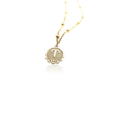 Close-up view of the Taurus zodiac sign pendant on a gold chain.
