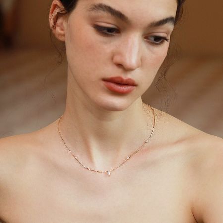Another view of the zircon charm necklace on a model, highlighting its delicate design.
