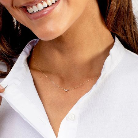 Elegant gold-plated sterling silver necklace with a three-stone cubic zirconia pendant.