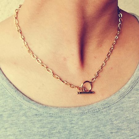 Model wearing the gold toggle pendant necklace to showcase its elegant look.