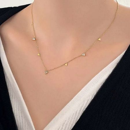 Model wearing the gold-plated sterling silver necklace with a triangular charm.