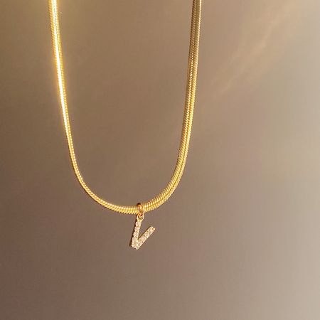 A stunning gold necklace showcasing the sparkling 'V' initial pendant.
