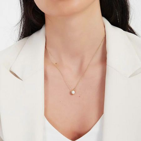 Side profile of a model wearing the gold necklace, highlighting its sophisticated look.