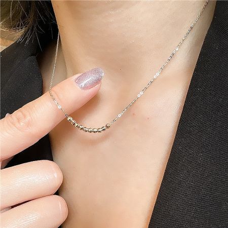 Model wearing the faceted bead choker necklace to demonstrate its flattering fit along the collarbone.