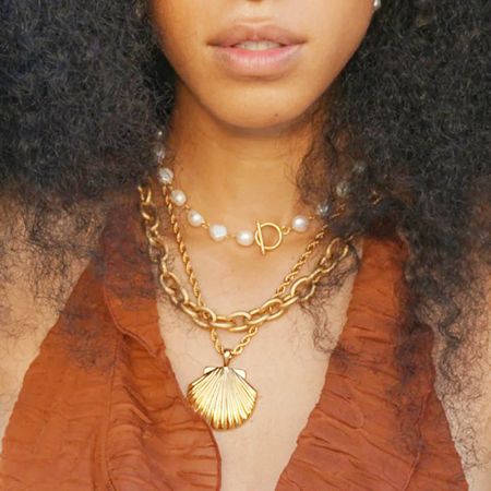 A collection of beach-themed necklaces including the scallop shell and a pearl design.