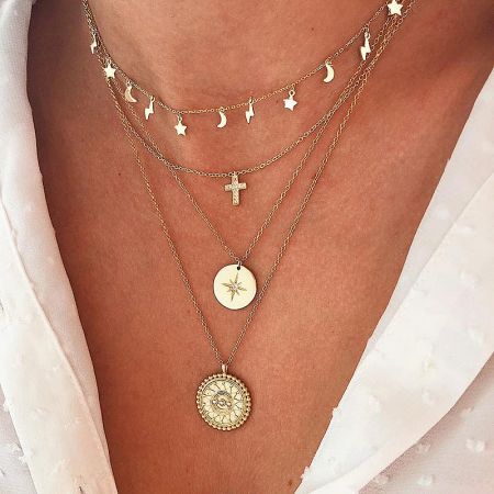 A collection of gold celestial-themed necklaces including the North Star pendant.
