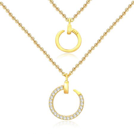 A close-up of the two distinct circular pendants, one smooth and one with sparkling cubic zirconia.