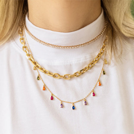 Collection of gold necklaces including the vibrant rainbow teardrop design.