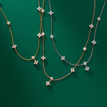 Three gold four-leaf clover necklaces displayed together to showcase their brilliant shine.