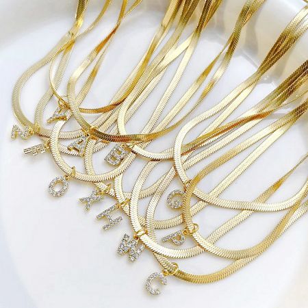 Stainless Steel Pave A-Z Initial Letter Snake Chain Necklace Set - A collection of stainless steel gold-colored snake chain necklaces, each featuring a sparkling pave A-Z initial letter pendant.
