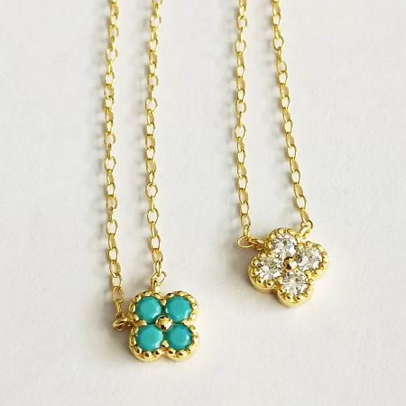 Top-down view of the two gold necklace variations with flower-shaped pendants.