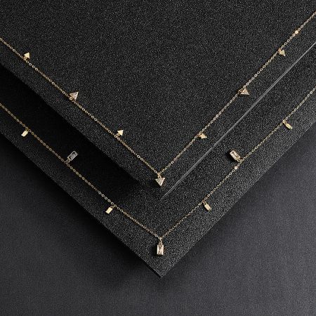 A pair of gold-plated sterling silver necklaces with geometric charms displayed side-by-side.