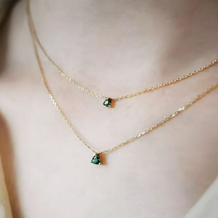 Styling example showing the emerald stone necklace layered with another piece.
