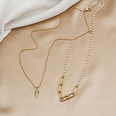 Detailed view of the gold-plated chain and pearl details of the necklace.
