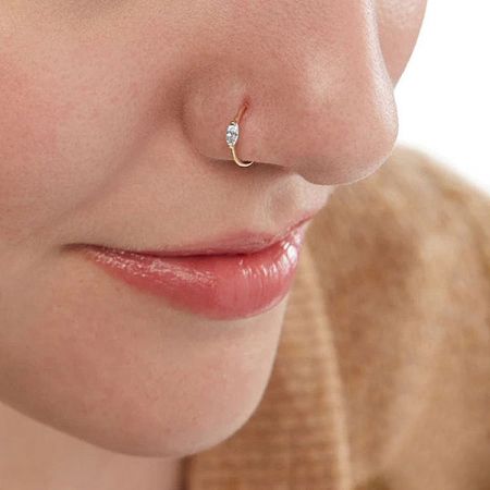 A model wearing a gold no-piercing nose cuff clip with a small diamond, demonstrating its stylish fit.