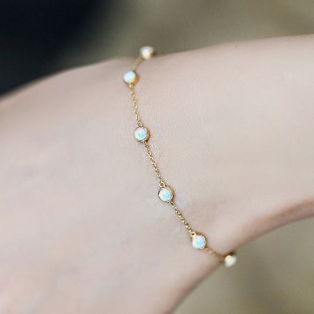 Detailed close-up of the gold-plated sterling silver bracelet with mini opal stones.