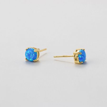 A detailed close-up of the ocean blue opal stud earring with a luxurious gold plating.