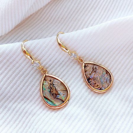 Close-up view of the gold teardrop earring highlighting the colorful mother of pearl stone.