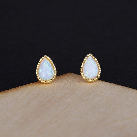 Detailed view of the gold teardrop opal earrings showcasing the intricate rope-like border.