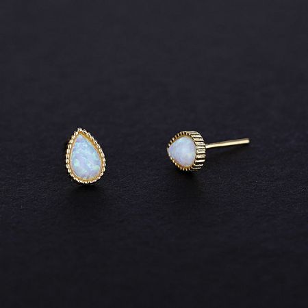 A pair of gold opal teardrop earrings highlighting the textured setting and iridescent stone.