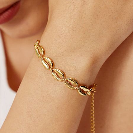 Gold oval link bracelet worn on a wrist.