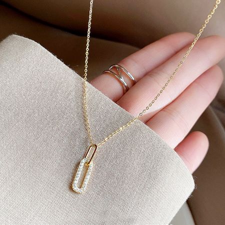 Close-up of the sparkling pavé CZ zircon oval pendant on the gold necklace chain.