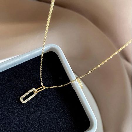 Angled view of the gold oval pavé CZ zircon pendant, showing its intricate detail and shine.