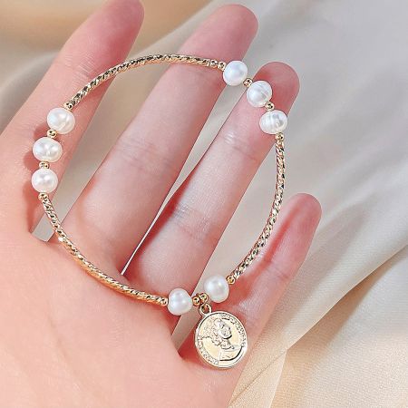 Elegant gold pearl bracelet with a classic coin charm, part of a five-piece set.